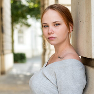 Portrait von Kim Schindler im Halbprofil draußen bei Tageslicht